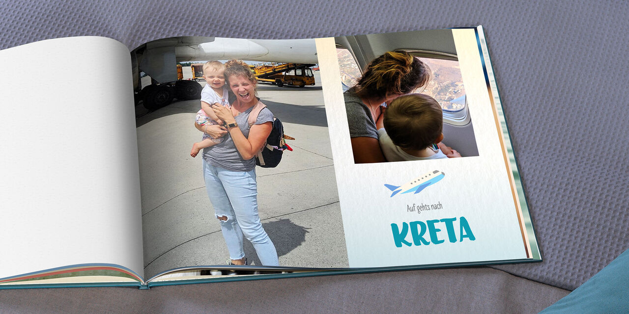 Ein aufgeschlagenes CEWE FOTOBUCH zeigt Magy und Hannah vor und in einem Flugzeug. Ein Clipart eines Flugzeugs und der Text "Auf gehts nach KRETA" lassen darauf schließen, wohin die Reise geht.